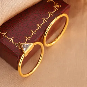 Detail of gold-plated rings with triangle-cut zircon on a decorative red box