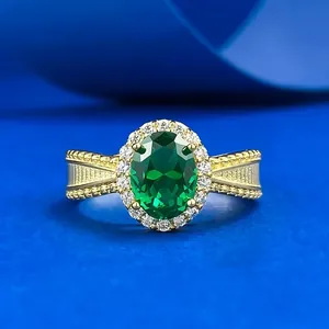 Detailed view of elegant gold ring featuring an oval green emerald and diamond halo