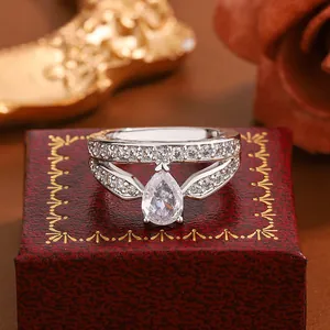 Close-up of a silver-toned ring with a large pear-shaped zircon on a red gift box