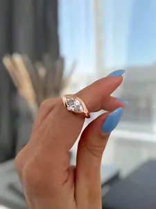 Close-up view of an elegant 18k gold plated marquise cut diamond engagement ring on a hand.