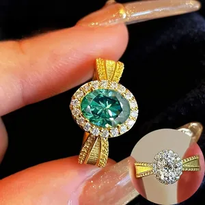 Close-up of an oval green gemstone ring with halo setting and gold textured band.