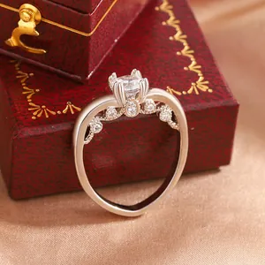 Close-up of a silver-tone ring featuring a large clear zircon and a four-prong setting.