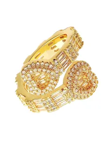Detail view of gold-plated hip-hop rings with micro-pave and baguette stones.
