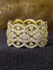 Close-up of a wide gold ring with intricate lattice pattern and micro-set rhinestones