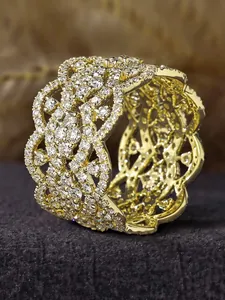 Detailed close-up view of micro-pave five-leaf flower rhinestone gold-tone wide cuff bracelet