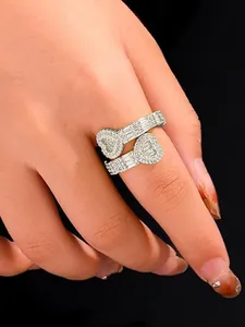 Detailed close-up of a silver iced-out double heart wrap ring on a model's finger