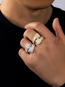 Detailed view of gold and silver square bypass rings with sparkling cubic zirconia on a hand