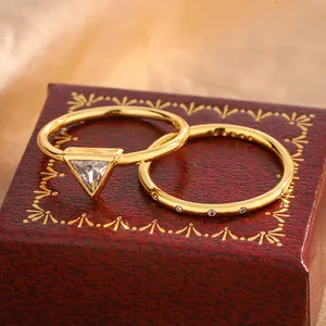Detailed view of two gold-plated rings featuring a sparkling triangular zircon stone