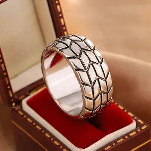 Close-up of a 6mm rhombus tire pattern ring displayed in a vintage red velvet jewelry box