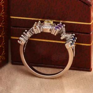 Detailed macro shot of an elegant silver ring featuring vibrant colorful gemstones