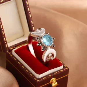 Detailed view of a blue zircon celestial ring featuring crescent moons in a jewelry box