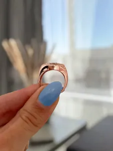 Elegant side view of an 18k gold plated marquise diamond signet ring held by hand