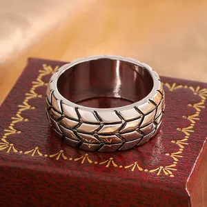 Macro detail of a 6mm men's tire tread pattern ring on a vintage red jewelry box.