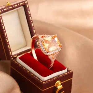 Detail shot of a rose gold ring with a large square yellow zircon in a luxury red box
