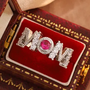 Close-up of MOM ring with red ruby stone and crystals in a vintage red box