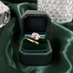 Detalle de un anillo de oro de 18k con banda ondulada y diamante en caja de terciopelo
