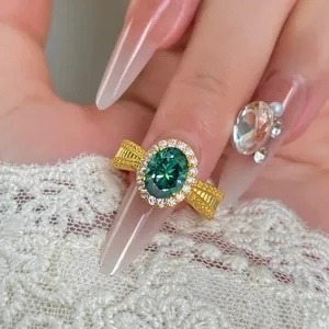 Elegant oval green gemstone ring with crystal halo and vintage gold band.