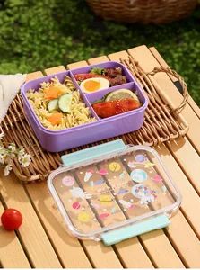 Close-up of a three-compartment purple plastic lunch box with a space themed cartoon lid