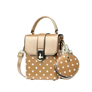 Stylish polka dot small crossbody bag with matching round coin purse and gold hardware.