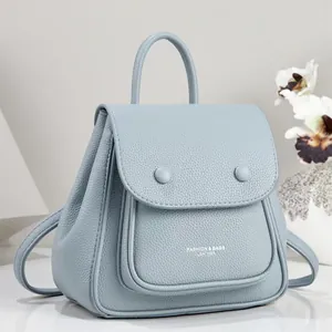Close-up of a light blue pebble leather backpack featuring elegant fashion bags branding