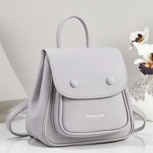 Detailed view of grey pebbled leather backpack with elegant top handle and flap pocket