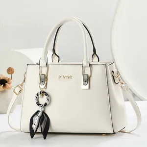 Elegante gebroken witte handtas met gouden KUOY-logo en decoratieve zijden sjaal bedel
