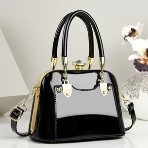 Elegant black patent leather handbag with gold hardware and crystal clasp.