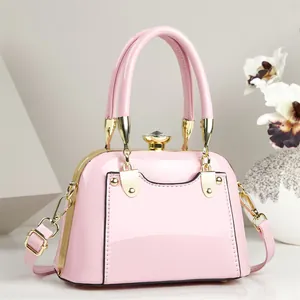 Elegant pink patent leather handbag with gold hardware and gemstone clasp, detailed view