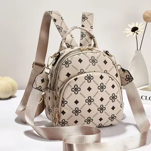 Vista dettagliata dello zaino beige multitasca con motivo monogramma elegante e cerniere