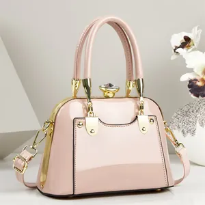 Elegant pink patent leather handbag with gold metal frame and jewel clasp detail