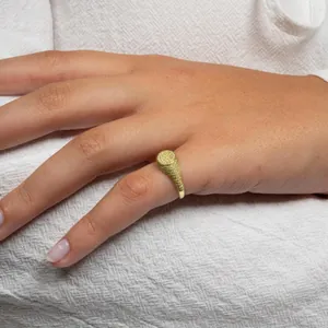 Luxurious gold-plated hip hop signet ring with full pavé oval yellow zircons on model hand