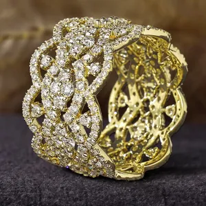 Intricate gold-toned wide ring with sparkling rhinestones and floral lattice design.