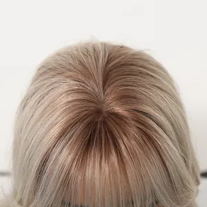 Close-up detail of realistic crown and rose gold ombre roots on a matte wig