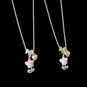 Close-up of Mori-style oil-dripped flower and heart pendants on silver necklace chains.