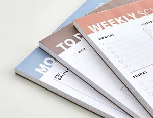 Detailed close-up showing the overlapping texture of tear-off weekly planner notepads