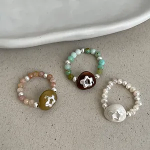 Handmade elastic rings featuring natural stones, freshwater pearls, and star motif charms.