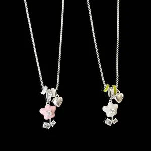 Detail of enamel flower pendant necklaces with heart charms and sparkling crystals