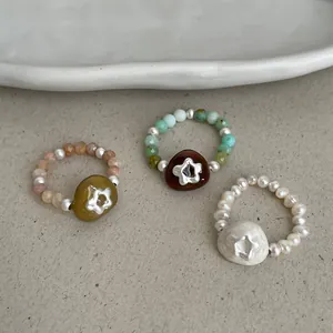 Handcrafted elastic rings with natural stones, pearls, and star cut-out details.