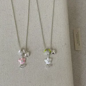 Detailed view of dainty floral enamel pendant necklaces with silver heart charms