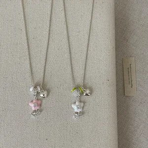 Close-up of sweet forest style flower pendant necklace with heart charm in pink and white