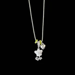 Detailed close-up of a silver necklace with a white enamel flower and small heart charm