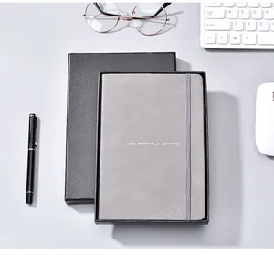 Grey PU leather business notebook in a premium black gift box on an office desk