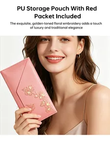 Vista detallada de la bolsa de PU rosa con bordado floral dorado sostenida por la modelo