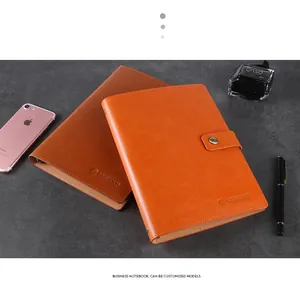 Close-up of premium faux leather business notebooks in orange and brown with embossed logo