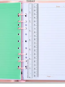Primer plano de cuaderno A5 con separador verde y regla de plástico transparente