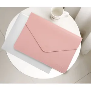 Vista detallada de una funda para portátil rosa mate estilo sobre en mesa blanca