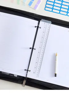 Detalle de papel para carpeta A5 con regla y pegatinas de etiquetas de colores.