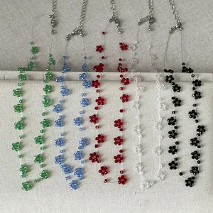 Handgemaakte kleurrijke kralenbloemenkettingen in groen blauw rood wit en zwart.