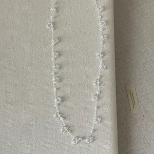 Gedetailleerd overzicht van handgemaakte kralenketting met bloemen op linnen