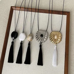 Detail view of Zen style tassel necklaces featuring elegant shell and stone pendants
